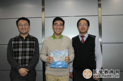 梁總及湯老師向2014年醫(yī)師面授班學員贈送正保公司臺歷并合影留念